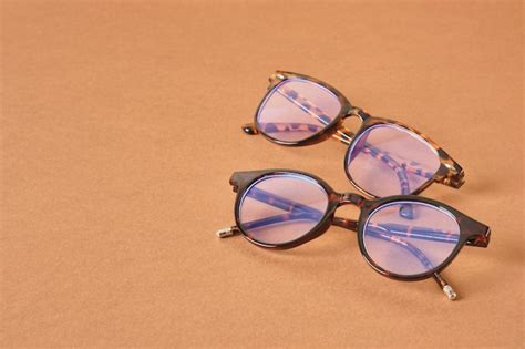 Premium Photo Two Pairs Of Beautiful Stylish Trendy Modern Eye Glasses On A Brown Background