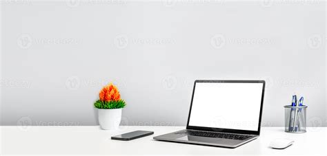 Blank white screen laptop on a white table in the office. Working ...