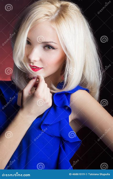 Blonde Hermoso Elegante De La Muchacha Con Los Labios Rojos En Un Vestido Azul En El Estudio