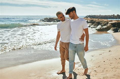 Joven Pareja Gay Sonriendo Feliz Caminando En La Playa Imagen De Archivo Imagen De Pares