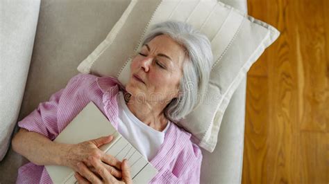 Top View Of Beautiful Mature Woman Asleep With Book Weekend Activity For Older Woman Relaxing