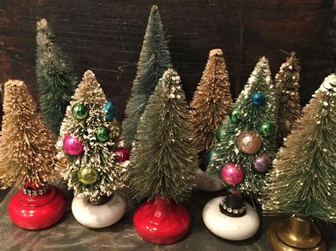 Vintage Bottle Brush Trees With Vintage Ornaments Sitting On Top Of Doorknobs Christmas