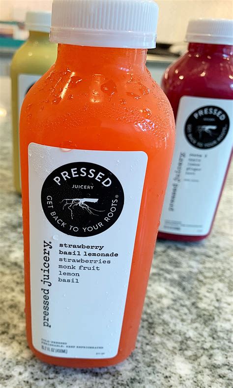 Three Bottles Of Juice Sitting On Top Of A Counter