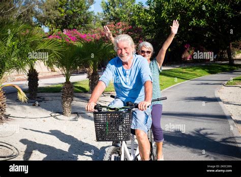Beautiful And Cute Couple Of Mature And Old Woman And Man Riding Together A Double Bike In A