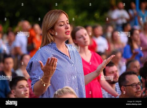 A Woman Praying And Singing In The Midst Of Many Other Pilgrims During