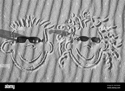 Face Drawn In The Sand On The Beach With Sunglasses Sand With Wave