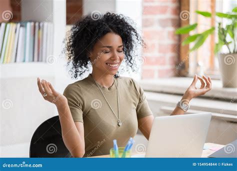 African Woman Sitting At Table In Workplace Do Yoga Exercise Stock