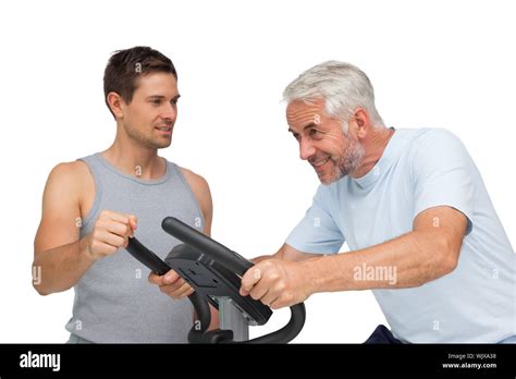 Determined Mature Man On Stationary Bike With Trainer Over White Background Stock Photo Alamy