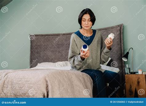White Mature Woman Examining Medicine While Sitting On Bed Stock Image Image Of Medicine