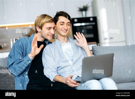 Homosexual Couple Online Communication Gay Couple Relax On The Couch In The Living Room Use A