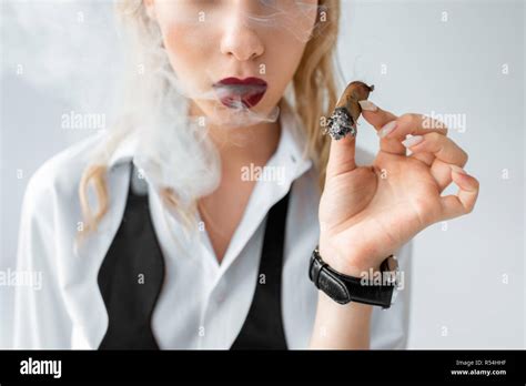 Portrait de jeune fille blonde à la mode de fumer un cigare sur gris Photo Stock Alamy