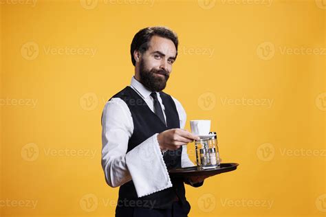 experienced waiter serving coffee  table pretending  hand  cup