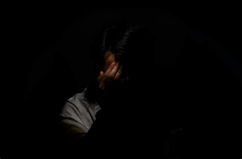 Asian Miserable Depressed Man Sitting Alone In Dark Background