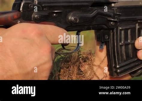 Close Up Of A Mans Hand Gripping The Handle Of A Sniper Rifle And
