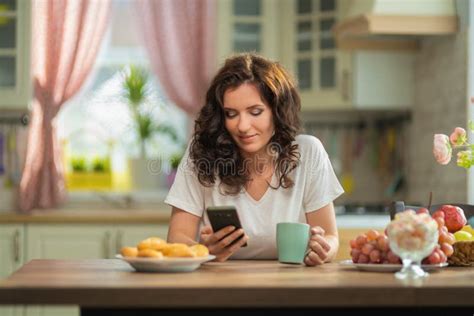 Brunette Woman Housewife In White T Shirt And Jeans At Home In The Interior Stock Photo Image