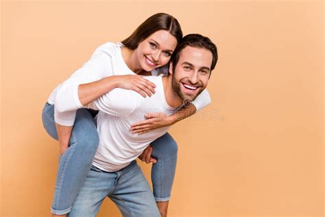 Photo Of Cute Millennial Brunette Couple Hug Play Wear Shirt Jeans Isolated On Beige Background