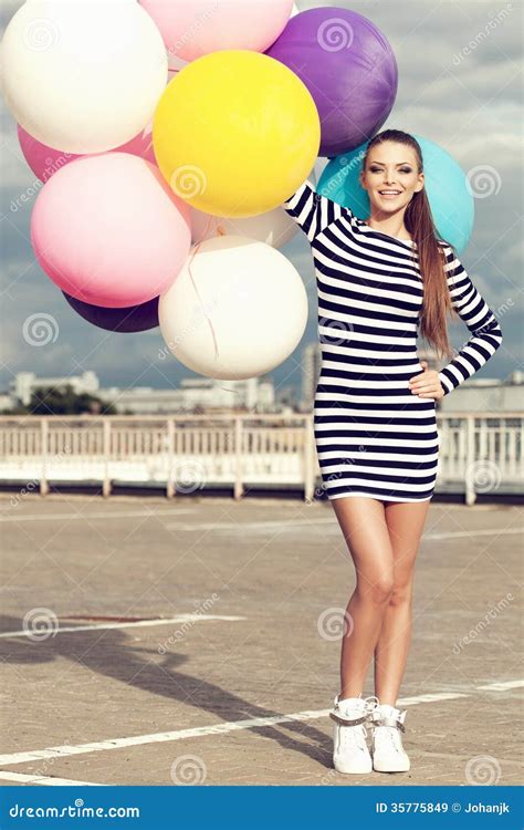 Счастливая молодая женщина с красочными воздушными шарами латекса ...