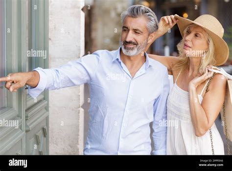 Mature Couple Browsing Shops And Pointing Stock Photo Alamy