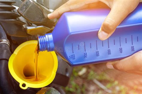 Chiudi A Mani Nude Versamento Meccanico Di Olio Nuovo Motore Per Il Motore A Motore Fotografia