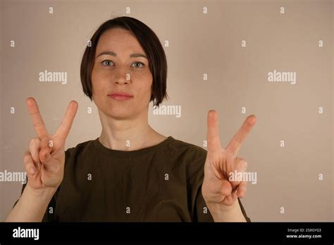 The Petite Woman Stands Confidently With Short Brunette Hair Neatly Styled Above Her Shoulders