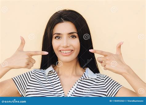 Portrait Of Pleasant Looking Brunette Female Has Appealing Look Indicates With Both Fore