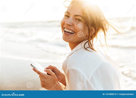 Image Of Beautiful Girl 20s Laughing And Using Mobile Phone While