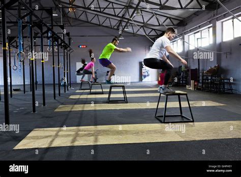 Athletes doing box jumps in gym Stock Photo - Alamy