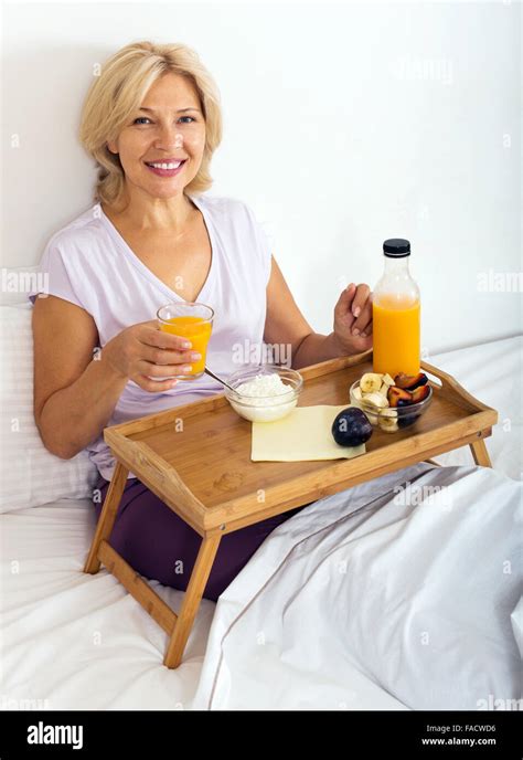 Happy Mature Woman Enjoying Breakfast In Bed Stock Photo Alamy