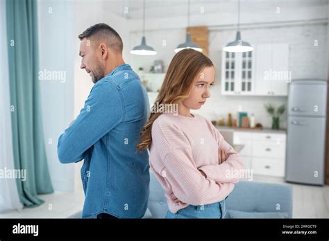 Father And Daughter Standing Back To Back Arms Crossed Stock Photo Alamy