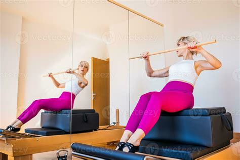 Blonde Woman Is Exercising On Pilates Reformer Bed In Her Home Stock Photo At Vecteezy