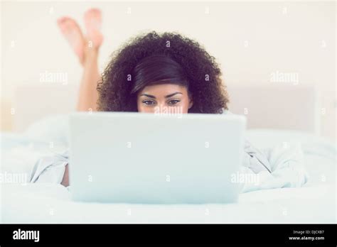 Pretty Brunette Lying On Bed Using Laptop Stock Photo Alamy