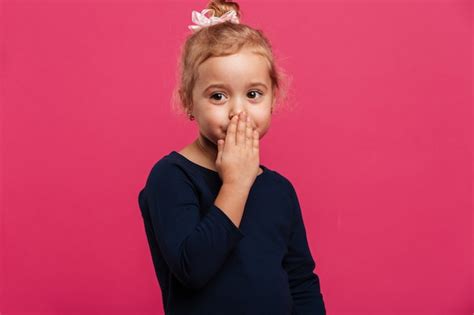 Jolie Jeune Fille Blonde Couvrant Sa Bouche Et Regardant De C T Sur Le Mur Rose Photo Gratuite