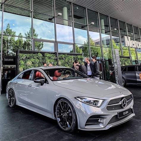 The Mercedes Benz Cla Is Parked In Front Of A Building With People