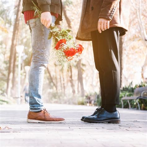 Pareja Gay De Cultivos Con Flores En El Parque Foto Gratis