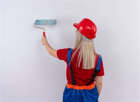 Jeune Fille Blonde Ing Nieur Constructeur En Peinture Uniforme Mur Avec Rouleau Peinture
