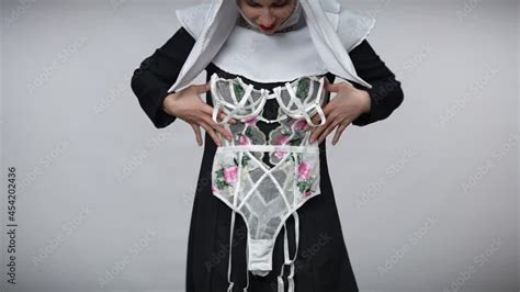 Unrecognizable Slim Woman In Nun Costume Putting Lace Lingerie On Body Smiling And Dancing At