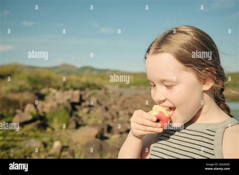 Girl Eating Apple In Countryside Stock Photo Alamy