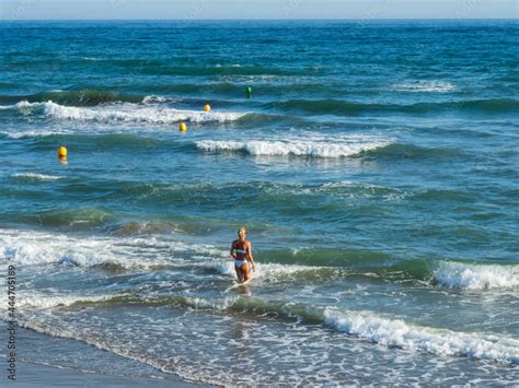 Mujer En Bikini Entrando En El Mar Entre Las Olas Stock Photo Adobe Stock