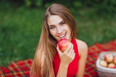 Jolie Fille Blonde Souriante Dans Le Parc Avec Apple Photo Gratuite