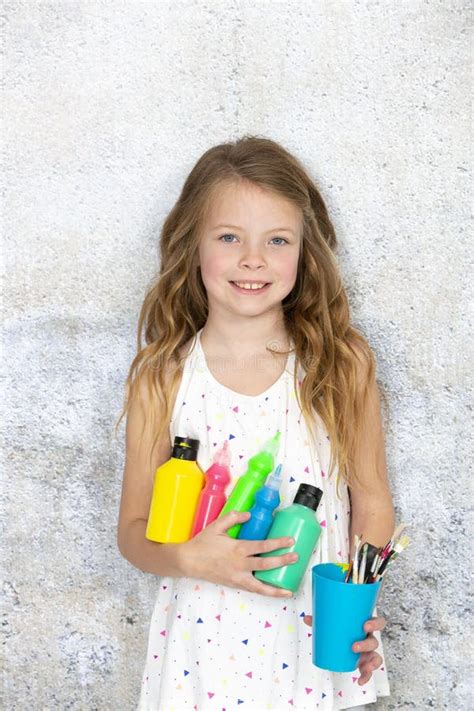Pretty Blonde Girl Holds Various Colourful Painting Utensils In Her