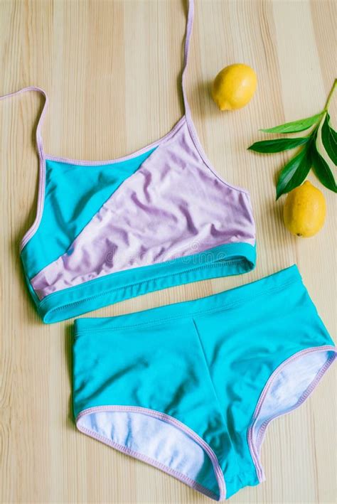 Bright Trendy Bikini On A Wooden Background With Yellow Lemons