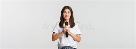 Shy Cute Brunette Girl Scared Of Singing In Public Standing With Microphone And Looking Nervous