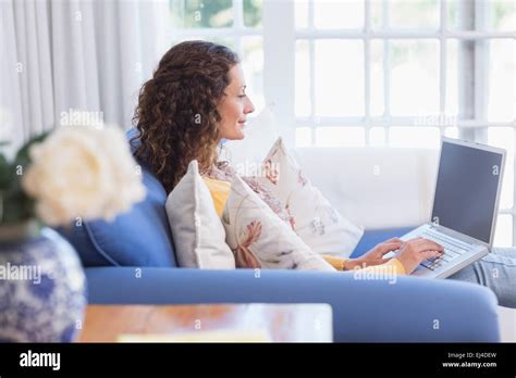 Pretty Brunette Relaxing On The Couch With Laptop Stock Photo Alamy