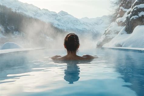 A Woman In A Hot Tub In Front Of A Snowy Mountain Premium AI Generated Image