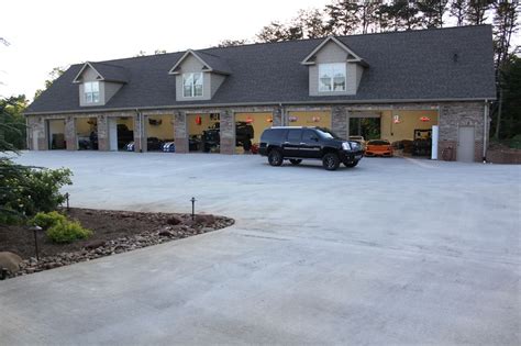 A Black Truck Parked In Front Of A Large Building With Two Garages On