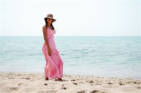 Jeune Femme Marchant Le Long De La Plage Avec Robe Rose Photo Gratuite