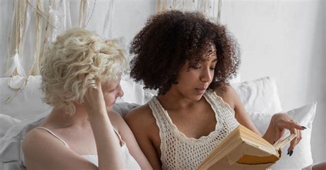 Multiracial Same Sex Couple Enjoying Reading Book In Apartment · Free