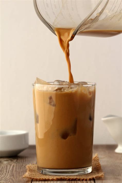 Vegan Iced Coffee Pouring From A Jug Into A Glass Full Of Ice Coffee