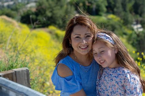 M E E Filha De Latina Que Sorriem E Que Riem Em Um Monte Na Frente Das Flores Amarelas Imagem De