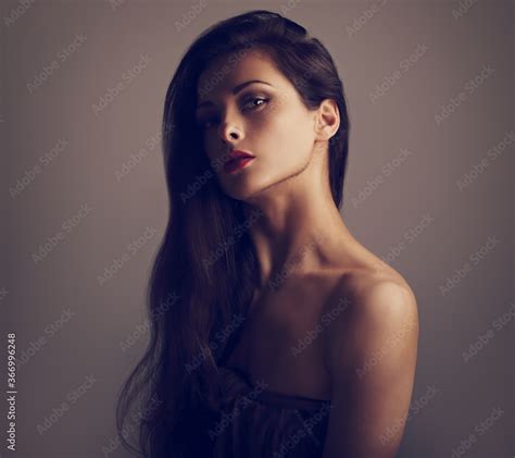 Beautiful Glamour Brunette Woman With Nude Shoulder And Long Curly Hair On Grey Background With
